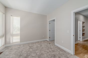 A room with a carpeted floor and a door. at Park Lamont Townhomes Apartments, Cleveland, OH, 44106
